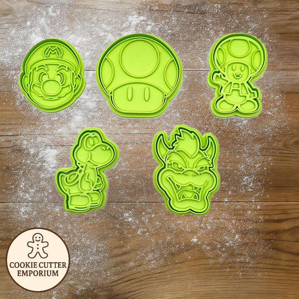 Set of green cookie cutters on a wooden surface with a rolling pin and checkered cloth.