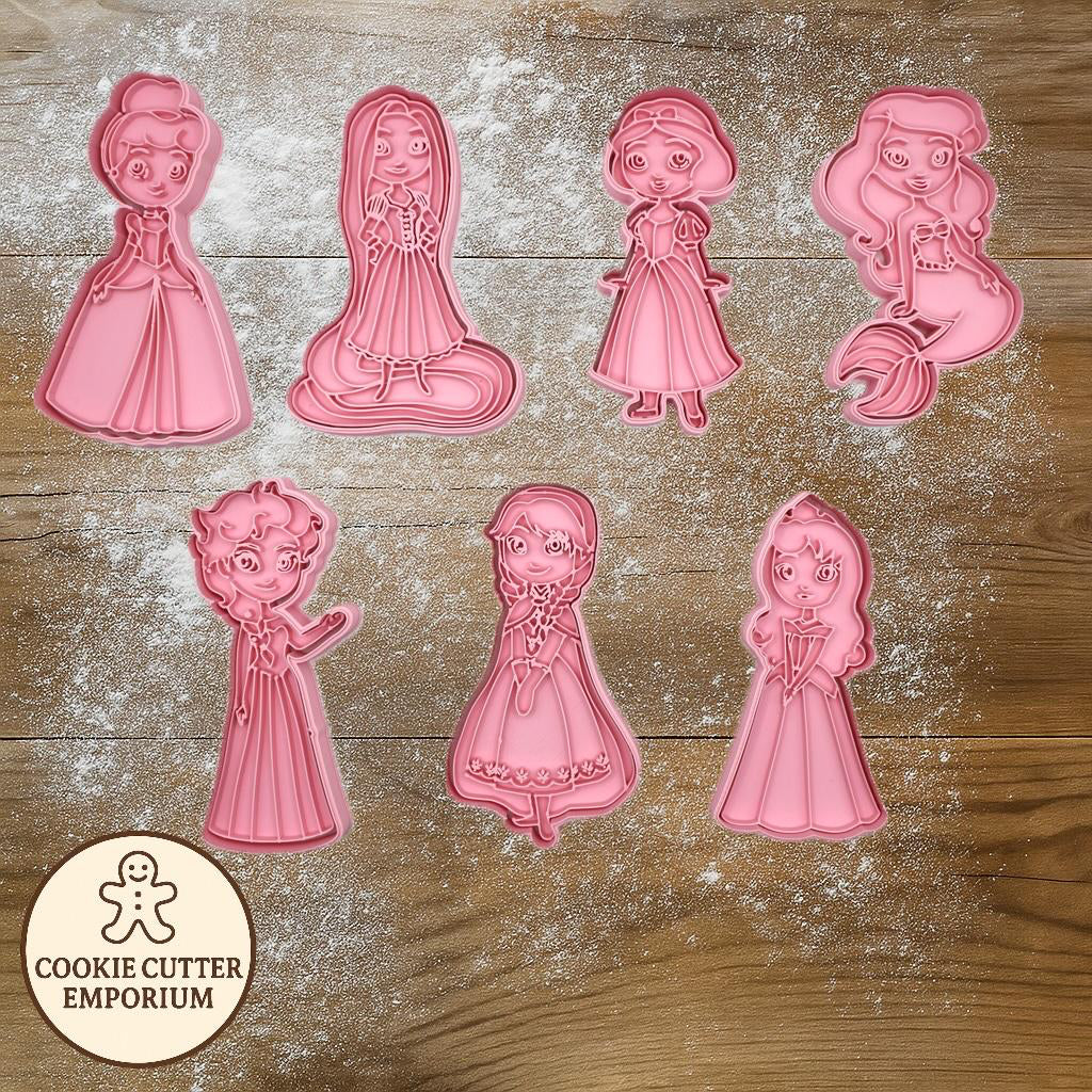Set of pink cookie cutters shaped like cartoon characters on a wooden surface with a rolling pin and checkered towel.