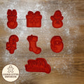 Red cookie cutters shaped like a bunny, gift, gingerbread man, stocking, and snowman on a wooden surface with a rolling pin and checkered cloth.