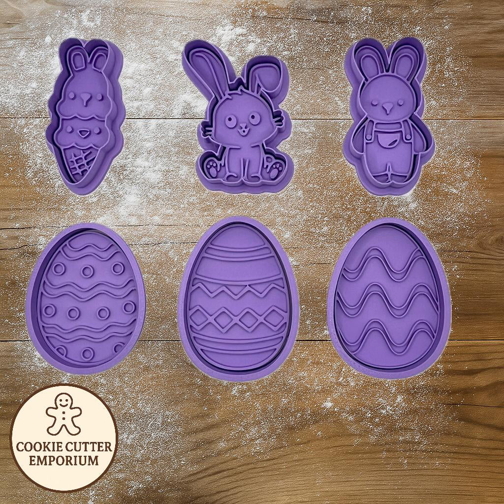 Purple Easter-themed cookie cutters on a wooden surface with a rolling pin and checkered towel.